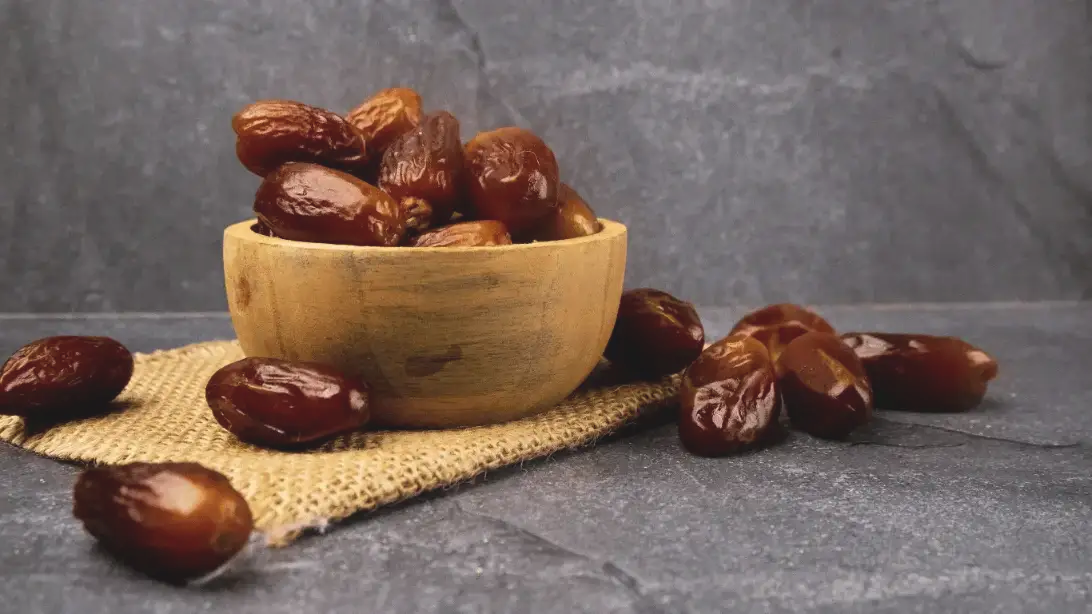 تصویر یک ظرف چوبی حاوی خرما