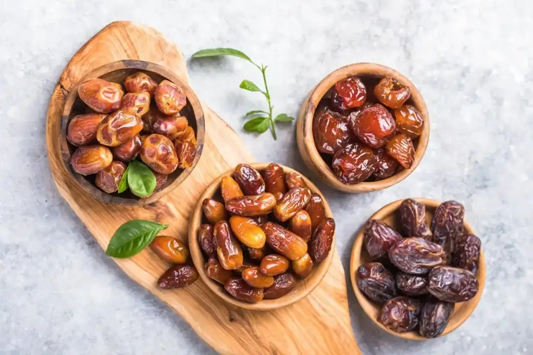 تصویر از چند نمونه خرمای مختلف چیده شده در ظروف چوبی
