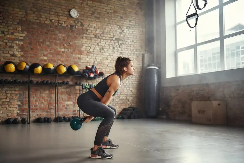 اجرای حرکت KettleBell Swing توسط یک خانم در باشگاه زنانه