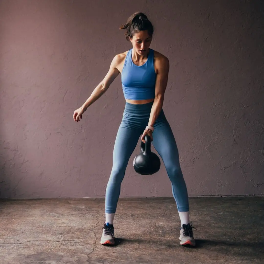 یک بانوی ورزشکار در حال اجرای تمرینات HIIT با کتل بل